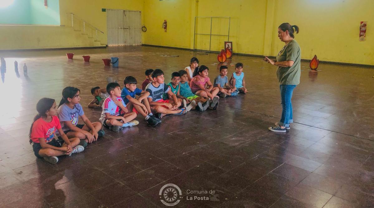 Foto de las coordinadoras indicando a los niños sentados