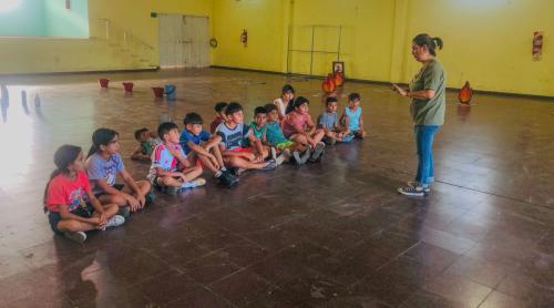 Foto de las coordinadoras indicando a los niños sentados